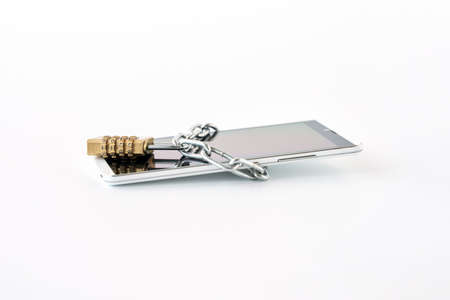 The smartphone is wrapped in a chain and closed with a combination lock. Concept: protection of...
