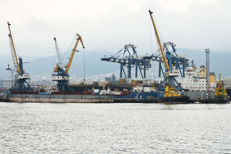 Loading and unloading operations in the water area of the sea cargo port in bad weather. Copy space.