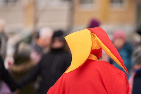 An animator in a bright clown costume at a festive street performance. Selective focus.