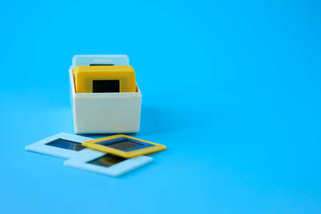 Old slides from the family archive in a box on a pale blue background. Copy space. Selective focus.の写真素材