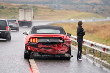 Crimea, Tavrida highway, September 19, 2021: accident on the road. A broken-down Ford Mustang convertible with a female car driver standing next to it.のeditorial素材