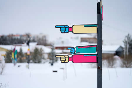 Information signs on a pole indicating the direction to the objects in the park. Selective focus.