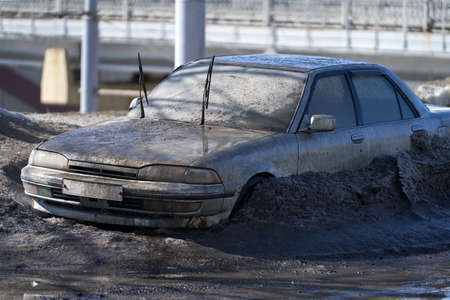 A lonely very dirty car after a long winter standing in a snowdrift. selective focus.