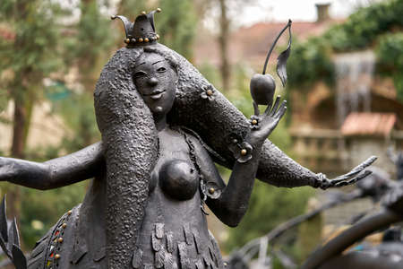 Russia, Kabardinka, April 11, 2021: Old Park. A fragment of a forged fairy-tale monster with an apple in his hand. selective focus.のeditorial素材