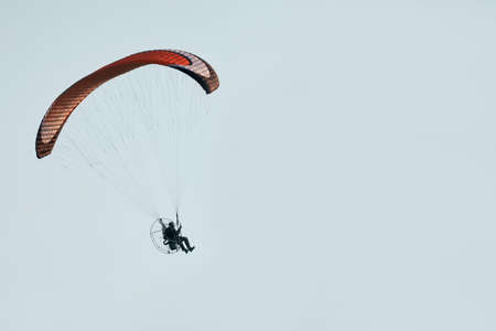 Route flight of a paraglider. A motorcycle paraglider in the air, against the sky. copyspace.