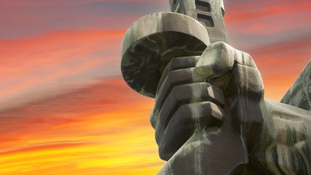 Russia, Novorossiysk, April 13, 2021: fragment of the memorial complex "Line of Defense". A man's hand clutching a machine gun against a tragic golden-red sky.のeditorial素材