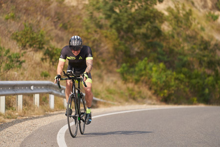 Russia, Anapa, September 16, 2021: a cyclist with the tension of climbing the mountain road. individual training.のeditorial素材