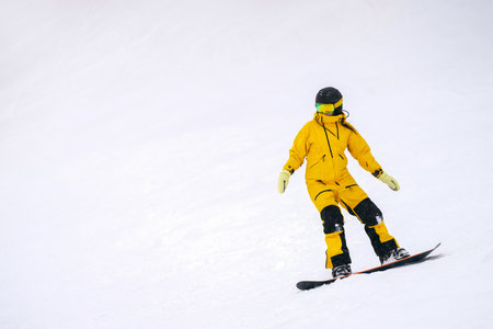 Lone figure of snowboarder rolling down white snow slope. Copy space.の写真素材