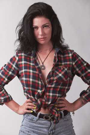 Tattooed brunette in plaid shirt on gray backgroundの写真素材