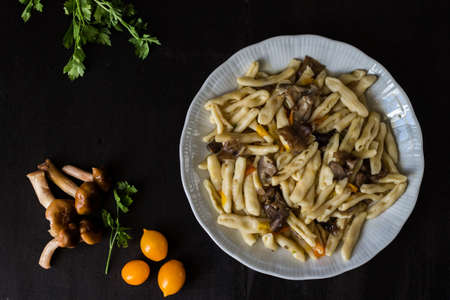 Cavatelli with pioppini mushrooms and yellow cherry tomatoes. Homemade pastaの写真素材