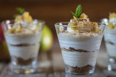 Mango mousse in glass cup with mint on wooden backgroundの写真素材