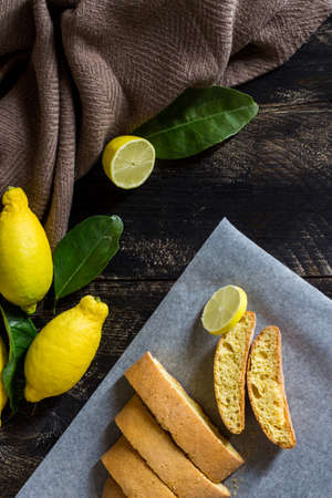 Homemade lemon cookies. Black wooden background with lemons and leaves.の写真素材