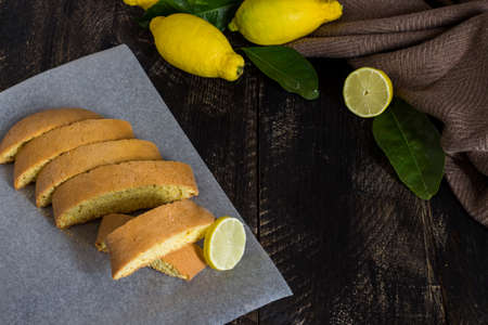 Homemade lemon cookies. Black wooden background with lemons and leaves.の写真素材