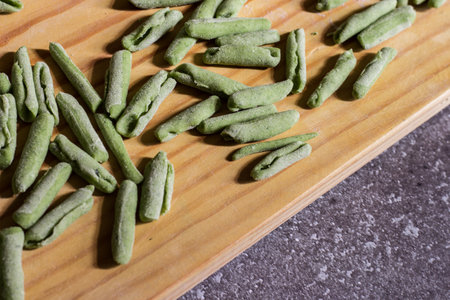 Cavatelli with spinach. Typical homemade Italian pasta on wooden cutting boardの写真素材