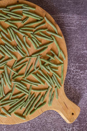 Green pasta with spinach. Typical homemade Italian pasta on wooden cutting board