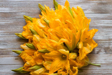Bouquet of courgette flowers on wooden backgroundの写真素材