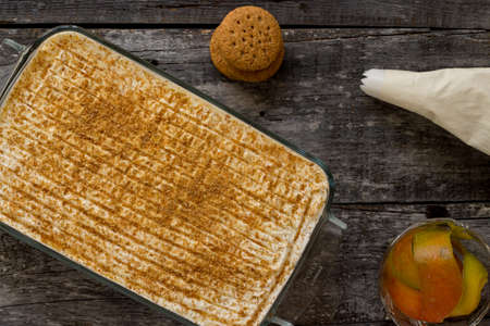 Tiramisu with mango. Modified dessert with pieces of mango, rum-soaked ladyfingers and crumbled...