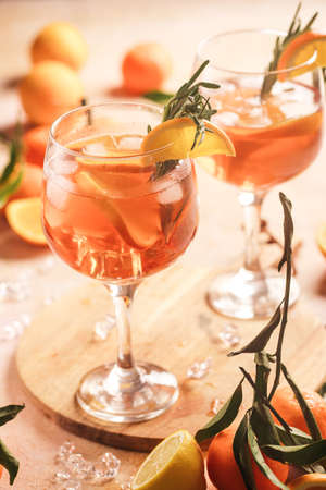 Orange christmas alcoholic beverage with oranges, tangerines and rosemary