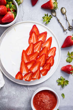 White cheesecake with sliced strawberries, top viewの写真素材