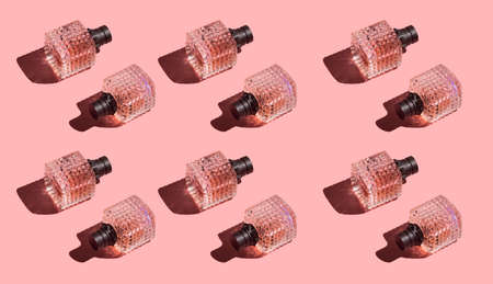 Hard light pattern of pink cosmetics container with black dispenser for perfume on pink backgroundの写真素材