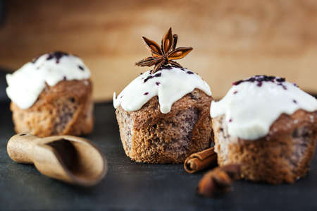 Holiday three muffins with blueberries, white frosting, cinnamon and star aniseの写真素材