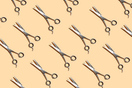 A hard light pattern of scissors for barber on pastel yellow background, a top viewの写真素材