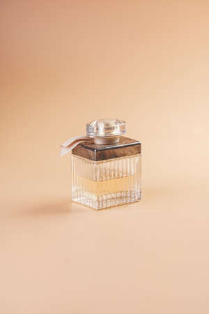 A gold cosmetics bottle with a dispenser for perfume on pastel yellow backgroundの写真素材
