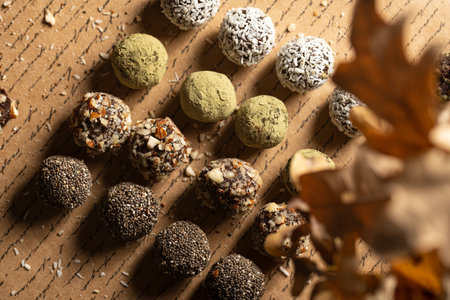 Homemade vegan peanut energy chocolate candy truffles with matcha, chia seeds, almonds and coconut flakes toppingの写真素材