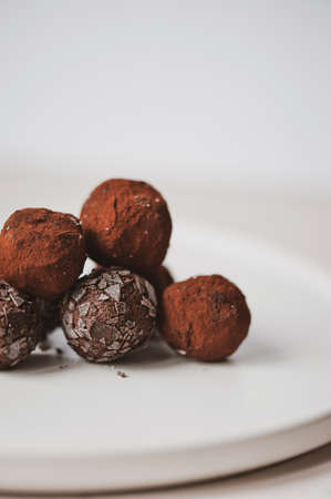 Homemade vegan peanut energy chocolate candy truffles with almonds and coconut flakes toppingの写真素材
