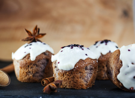 Festive blueberry muffins with white frosting, cinnamon and star aniseの写真素材