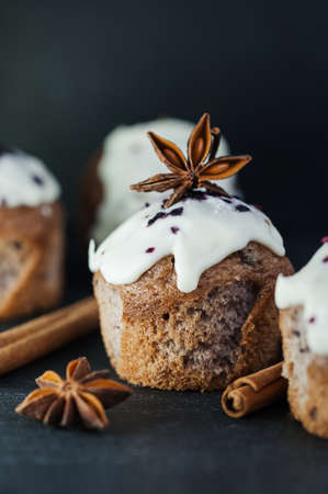 Festive blueberry muffins with white frosting, cinnamon and star aniseの写真素材