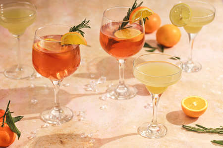 Orange christmas alcoholic beverage and lemonade with oranges, mandarins and rosemary in many glassesの写真素材