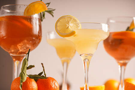 Orange christmas alcoholic beverage and lemonade with oranges, tangerines and rosemary in many glassesの写真素材