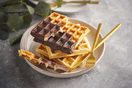 Breakfast waffles with chocolate with golden silverware on gray surfaceの写真素材