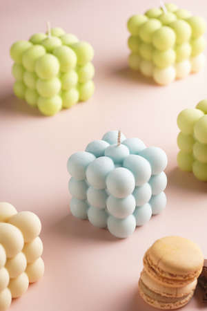 Blue bubble candle surrounded by bright bubble candles on a pink surfaceの写真素材