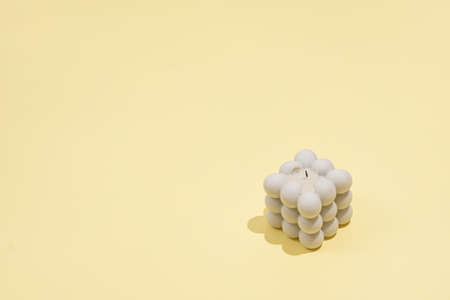 A gray bubble candle on a yellow background, negative spaceの写真素材