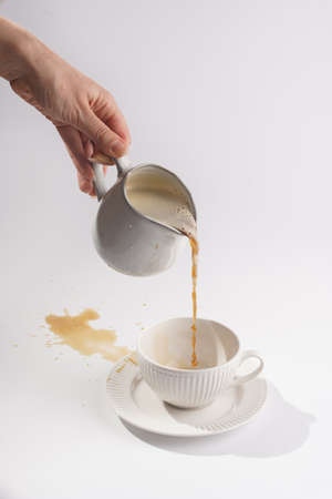 A white porcelain cup with coffee drink cappuccino on a white saucer plate on a white surfaceの写真素材