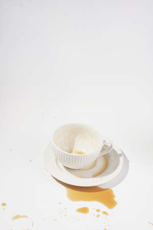 An empty cup with coffee drink on a white saucer plate on a white surfaceの写真素材