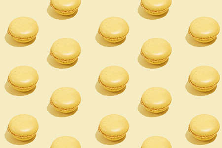 Hard light pattern of a yellow macaron pastry on bright yellow backgroundの写真素材