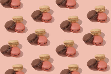 Hard light pattern of a creamy, pink and chocolate macaron pastry on pink backgroundの写真素材