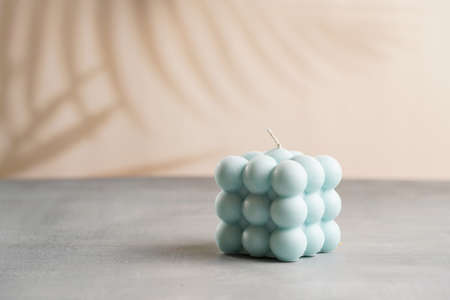 One blue square bubble candle on a gray surfaceの写真素材