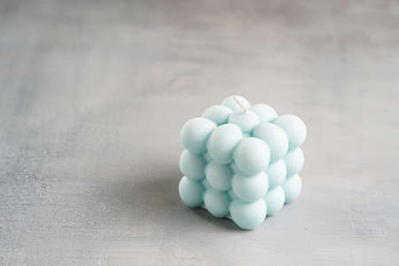 One blue square bubble candle on a gray surfaceの写真素材