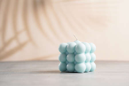 One blue square bubble candle on a gray surfaceの写真素材