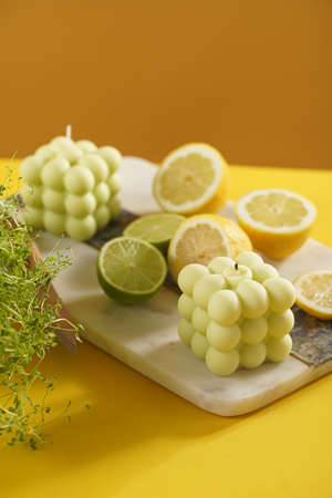 green and white bubble candle surrounded by lemon and lime halves, fresh thymeの写真素材