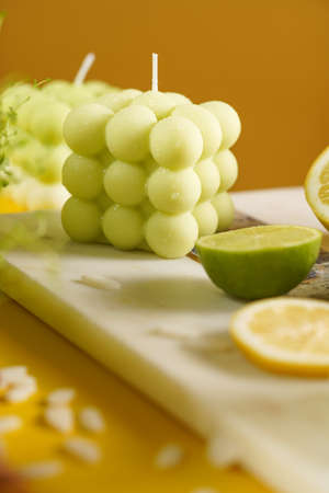 green and white bubble candle surrounded by lemon and lime halves, fresh thymeの写真素材