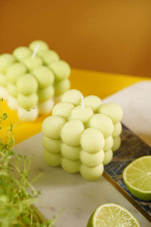 green and white bubble candle surrounded by lemon and lime halves, fresh thymeの写真素材