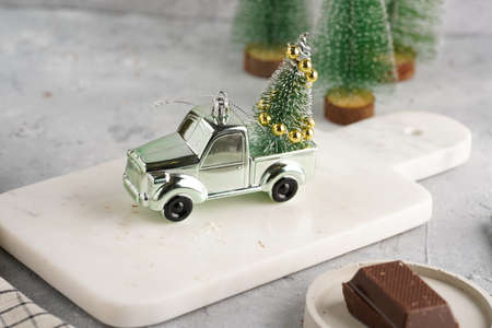 Christmas tree ornament - silver car with a fair tree. A holiday toy on a marble boardの写真素材