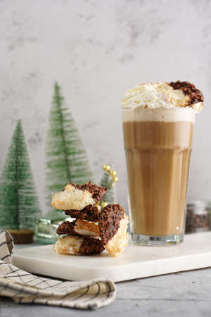 Several coconut flakes cookies dipped in chocolate on a white marble board, christmas decorationの写真素材