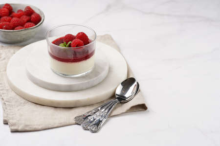 Italian dairy dessert panna cotta with raspberry jam, fresh raspberries and mint on round marble boards, copy spaceの写真素材