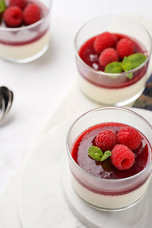 Italian dairy dessert panna cotta with raspberry jam and fresh raspberries on marble boardの写真素材